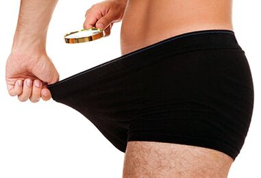 một người đàn ông nhìn vào kích thước dương vật của mình